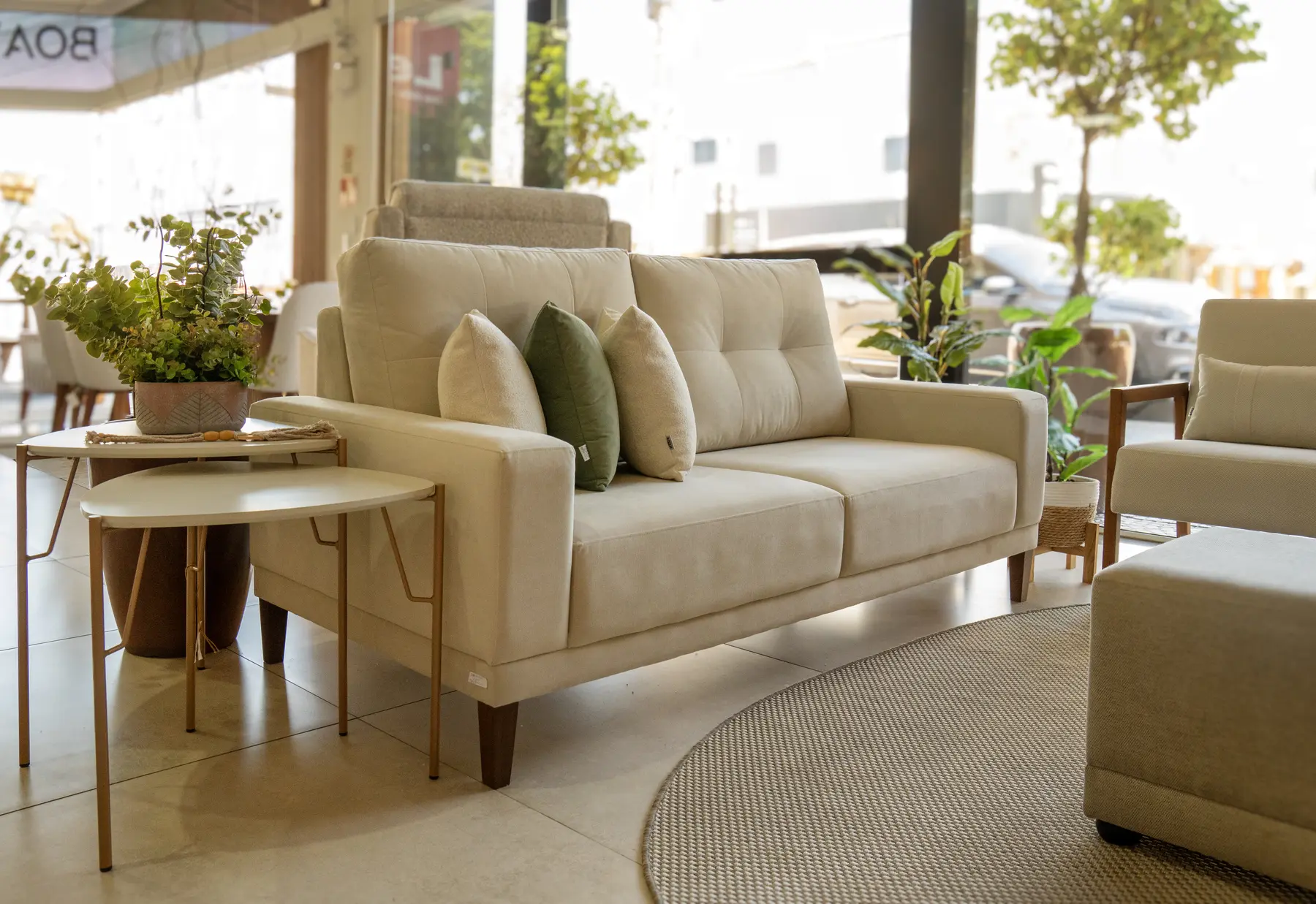 Sofá Haus em nosso showroom, com tecidos claros e mesas em madeira